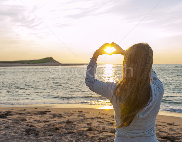 Ragazza holding hands a forma di cuore spiaggia giovane ragazza Foto d'archivio © elenaphoto