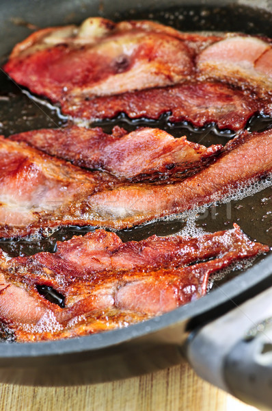Stock photo: Bacon frying in a pan