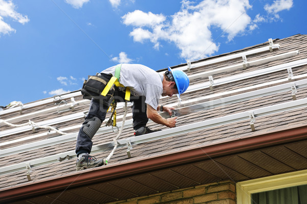Férfi dolgozik tető installál napelemek lakóövezeti Stock fotó © elenaphoto