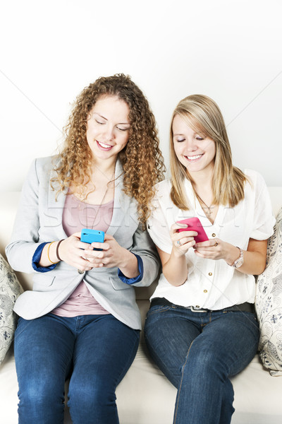 Two women using mobile devices Stock photo © elenaphoto