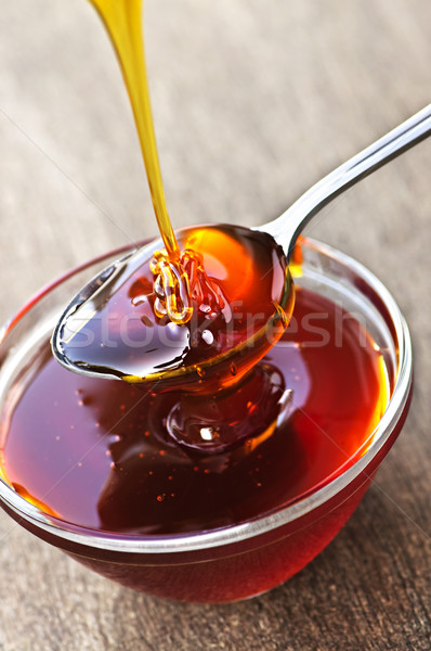 Honey dripping onto spoon Stock photo © elenaphoto