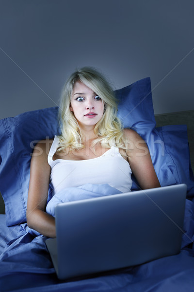 Stock photo: Frightened woman with computer at night