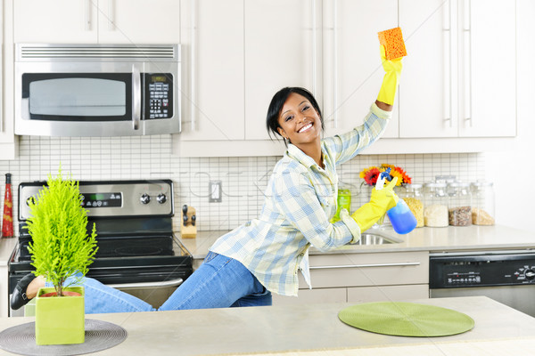 Jeune femme nettoyage cuisine souriant jeunes femme noire [[stock_photo]] © elenaphoto