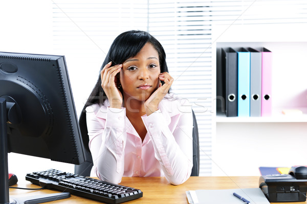 Worried black businesswoman at desk Stock photo © elenaphoto