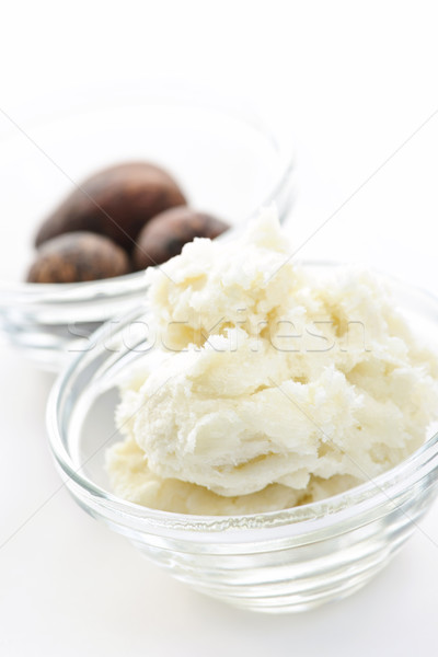 Shea butter and nuts in bowls Stock photo © elenaphoto
