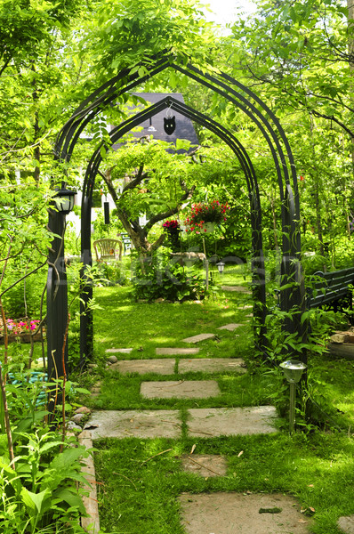 üppigen grünen Garten Eisen Laube Blumen Stock foto © elenaphoto