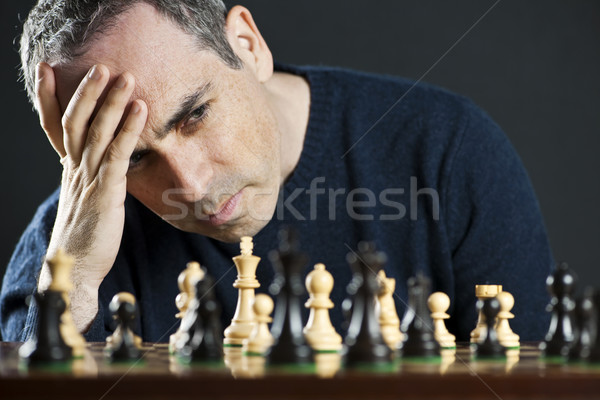 Uomo scacchiera scacchiera pensare scacchi strategia Foto d'archivio © elenaphoto
