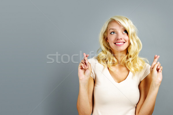Happy woman crossing fingers Stock photo © elenaphoto