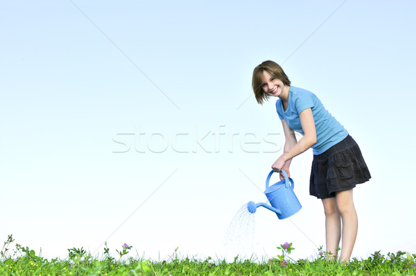 女孩 噴壺 微笑 十幾歲的女孩 綠草 天空 商業照片 © elenaphoto