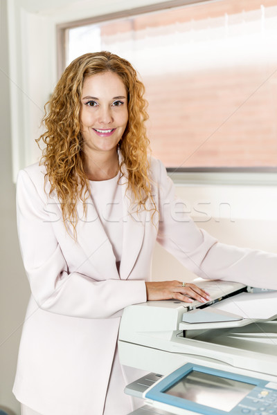 Businesswoman using photocopier in office Stock photo © elenaphoto