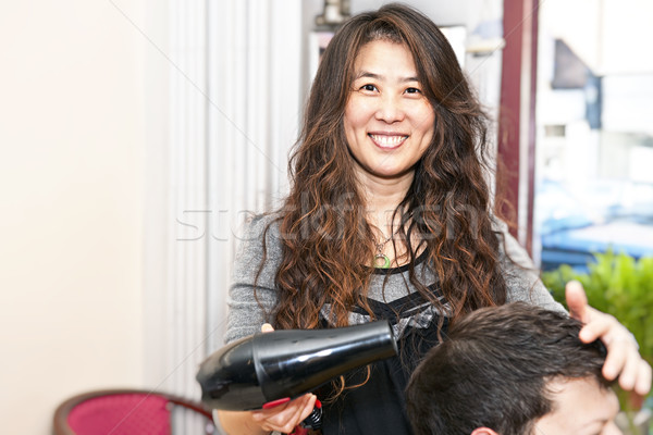 Pelo estilista de trabajo sonriendo secadora de pelo salón Foto stock © elenaphoto