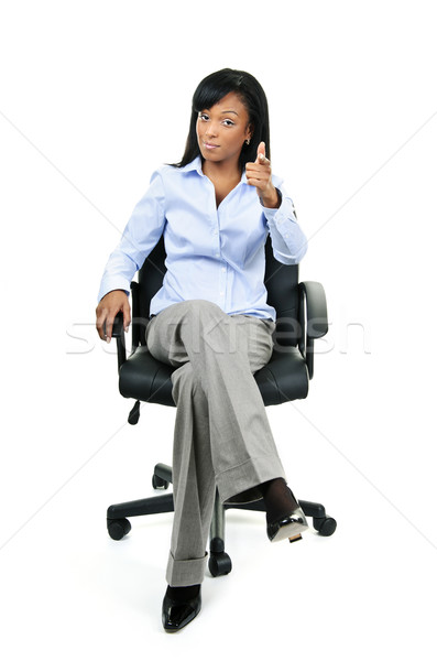 Businesswoman pointing sitting on office chair Stock photo © elenaphoto