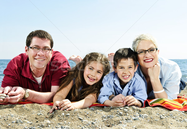 Gelukkig gezin strand leggen handdoek zandstrand familie Stockfoto © elenaphoto