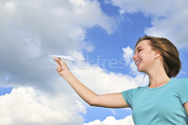 Stock photo: Young girl holding paper airplane