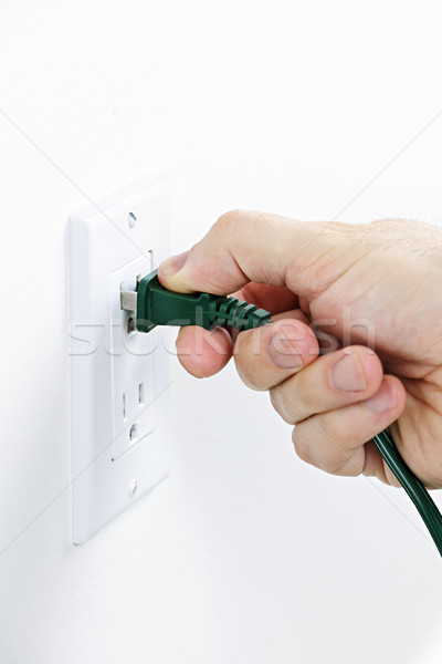 Hand inserting plug into outlet Stock photo © elenaphoto