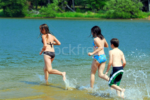 Foto stock: Ninos · ejecutando · agua · grupo · jóvenes · playa