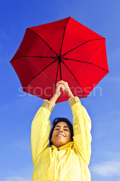 Beautiful young woman in raincoat with umbrella Stock photo © elenaphoto