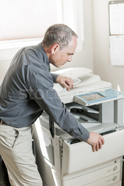 Man opening photocopier in office Stock photo © elenaphoto