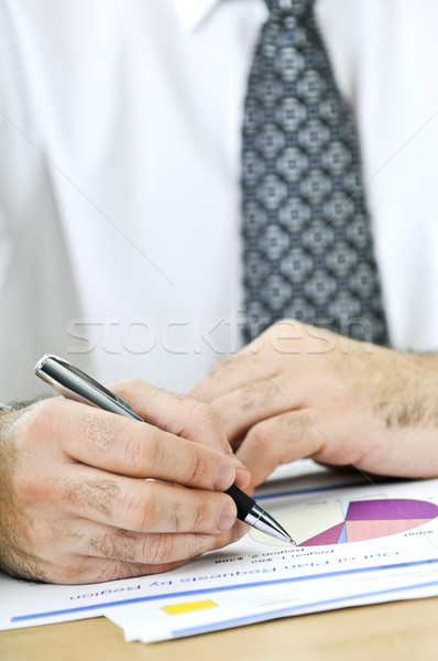 Office worker writing on reports Stock photo © elenaphoto