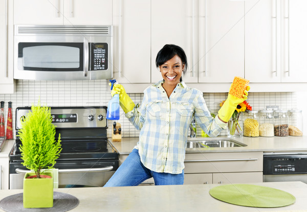 Jeune femme nettoyage cuisine souriant jeunes femme noire [[stock_photo]] © elenaphoto
