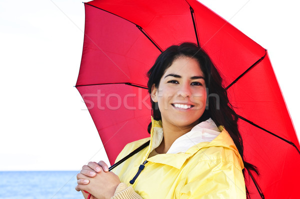 Beautiful young woman in raincoat with umbrella Stock photo © elenaphoto