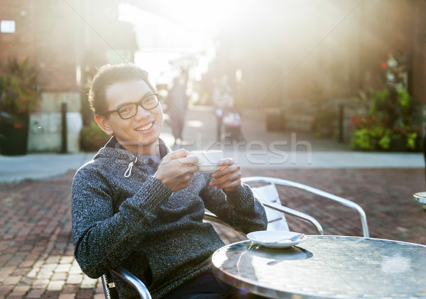 Young asian man in outdoor cafe Stock photo © elenaphoto