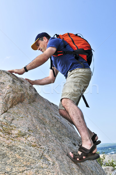 Hombre escalada mochila rock feliz Foto stock © elenaphoto