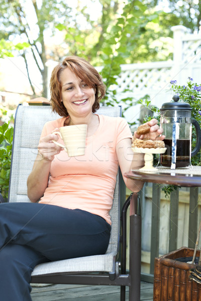Woman in backyard with coffee and cookies Stock photo © elenaphoto