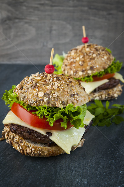 Kettő gurmé hamburgerek sajt friss zöldségek étel Stock fotó © elenaphoto