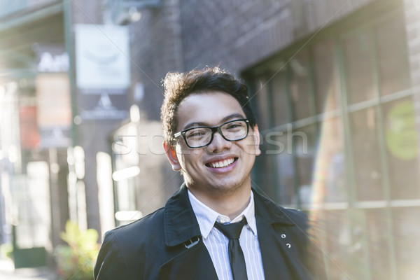 Young asian man on city street Stock photo © elenaphoto