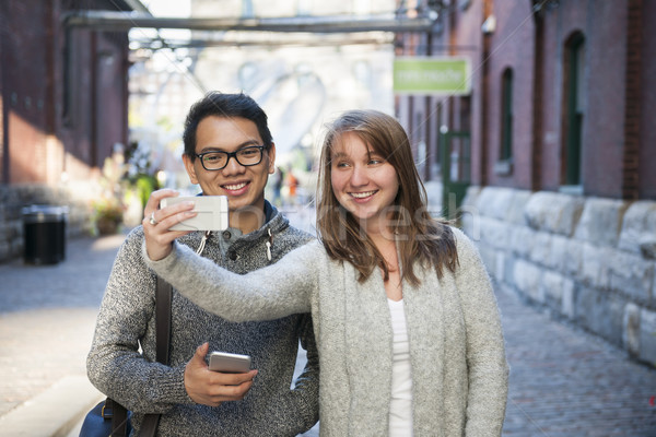 Two young people taking a selfie with smartphone Stock photo © elenaphoto