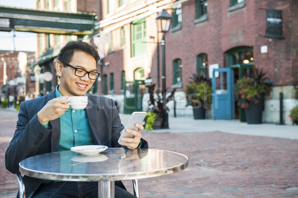 Young asian man in outdoor cafe Stock photo © elenaphoto