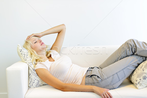 Tired woman laying on couch Stock photo © elenaphoto