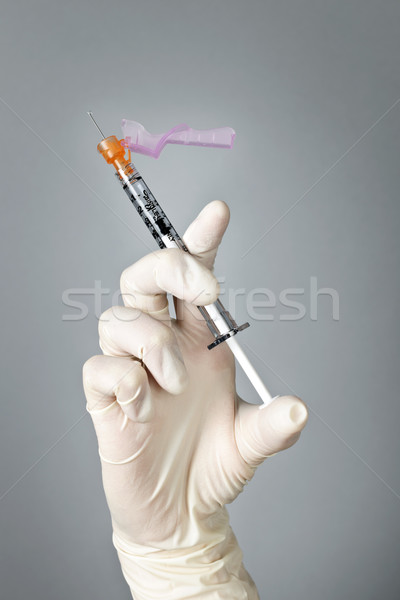 Syringe held by gloved hand Stock photo © elenaphoto