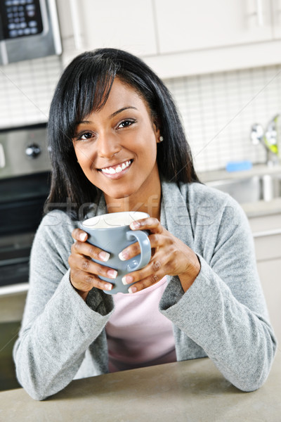 Donna cucina tazza di caffè sorridere donna nera Foto d'archivio © elenaphoto