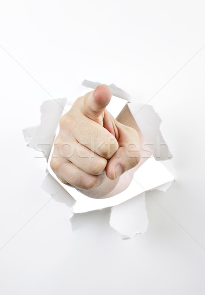 Finger pointing through hole in paper Stock photo © elenaphoto