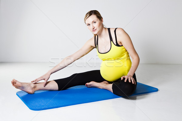 Stock photo: Pregnant woman performing leg stretch