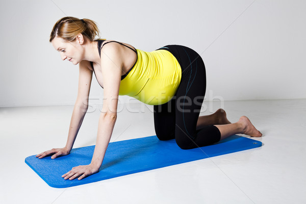 Pregnant woman kneeling on mat Stock photo © ElinaManninen