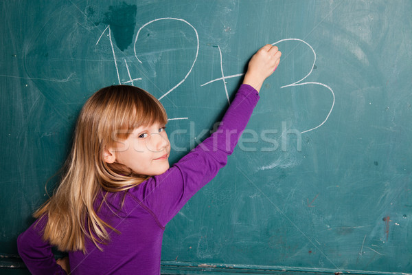 商業照片: 年輕的女孩 · 寫作 · 數字 · 黑板 · 粉筆 · 看