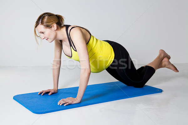 Pregnant woman doing push-up exercise Stock photo © ElinaManninen