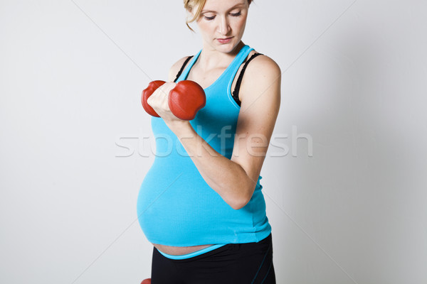 беременная женщина гантели мышцы женщину улыбка Сток-фото © ElinaManninen