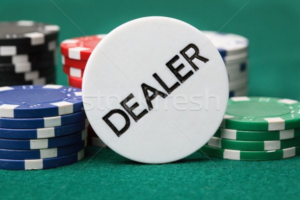 Handelaar knop poker chips groene oppervlak Stockfoto © ElinaManninen