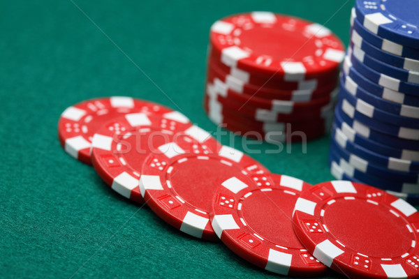 Poker chips spread out over a green surface.  Stock photo © ElinaManninen