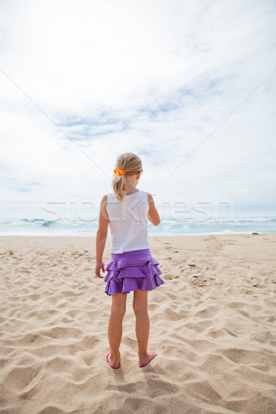 Jong meisje permanente strand strandzand naar oceaan Stockfoto © ElinaManninen