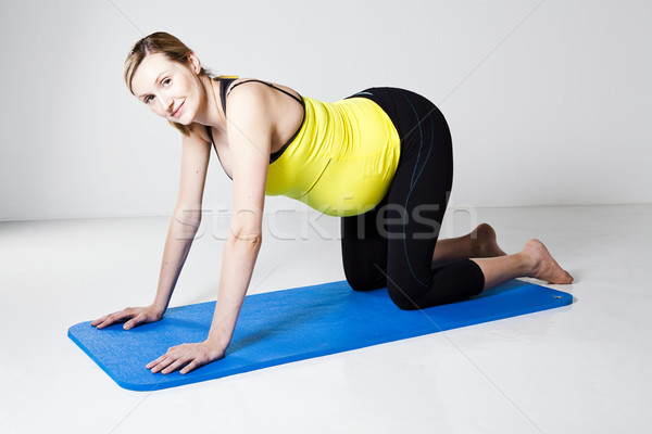 Pregnant woman kneeling on mat Stock photo © ElinaManninen