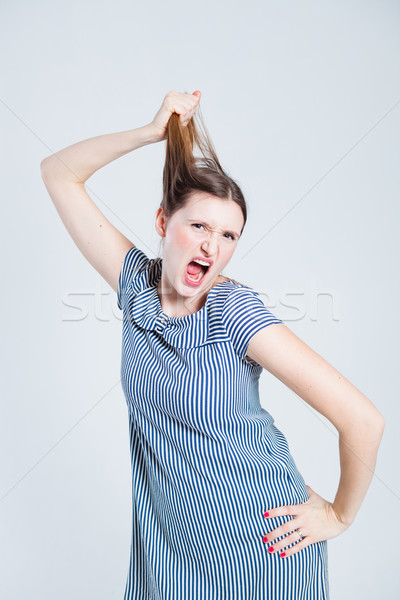 Attractive woman pulling her hair Stock photo © ElinaManninen