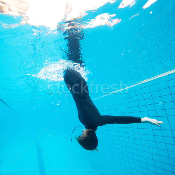 Female diving downwards in swimming pool Stock photo © ElinaManninen