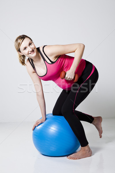 Pregnant woman exercising with dumbbells Stock photo © ElinaManninen