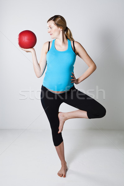 Pregnant woman exercising with exercise ball while balancing Stock photo © ElinaManninen