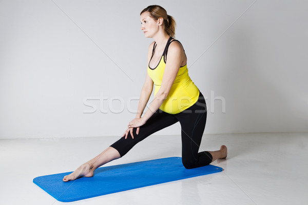 Pregnant woman performing leg stretch Stock photo © ElinaManninen